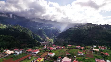 Aerial-view-of-house-on-a-green-hill-with-mountain-valley-background