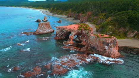 coastal arch and red rocks at the ocean shore