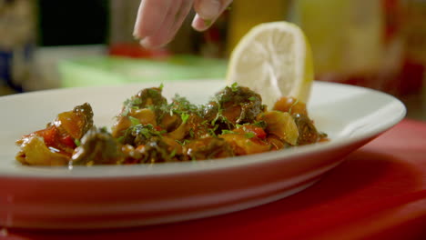 handheld - finely chopped basil or coriander being added to the snails