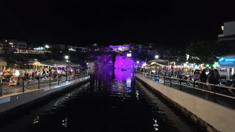 view of peoples relaxing in the ancient venetian port of rethymno at night, crete,greece