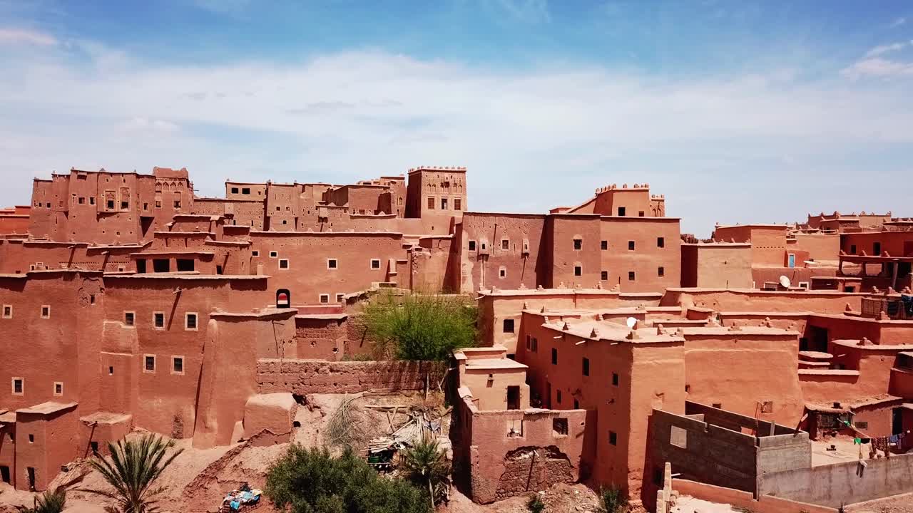 Vista panoramica di un villaggio fortificato in mattoni di fango (Ksar) che mostra la tradizionale architettura berbera in terra nella regione dell'Alto Atlante del Marocco.
