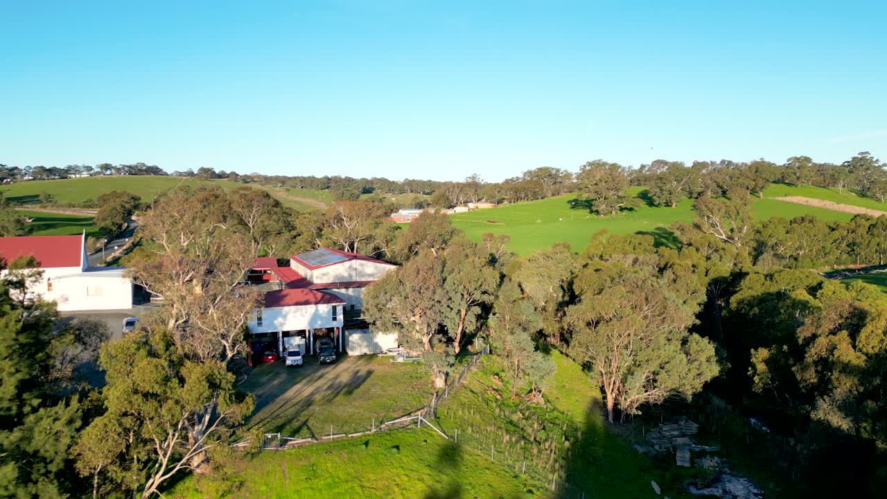 Aerial View of a Picturesque Rural Property with Farm Buildings and Lush Green Fields