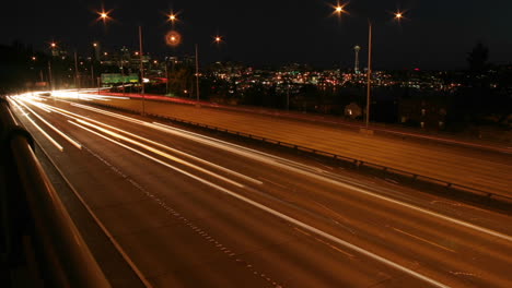 traffic drives along a seattle freeway at night