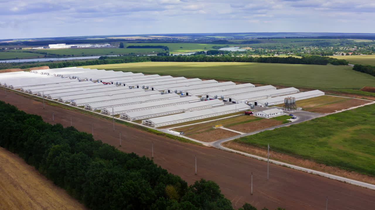 Large farm in rural place in summer. Modern agricultural buildings surrounded by amazing nature in the countryside. Aerial view.