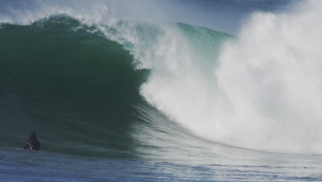 powerful wave crashing during golden hour, with sunlight illuminating the crest and white water in slow motion