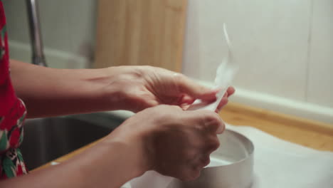 woman puts cooking oil onto wax paper