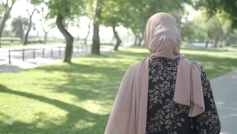 mujer en hijab caminando en un parque