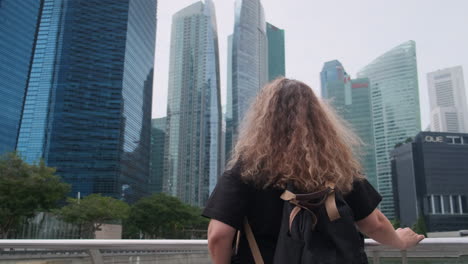 mujer mirando rascacielos en la ciudad de singapur