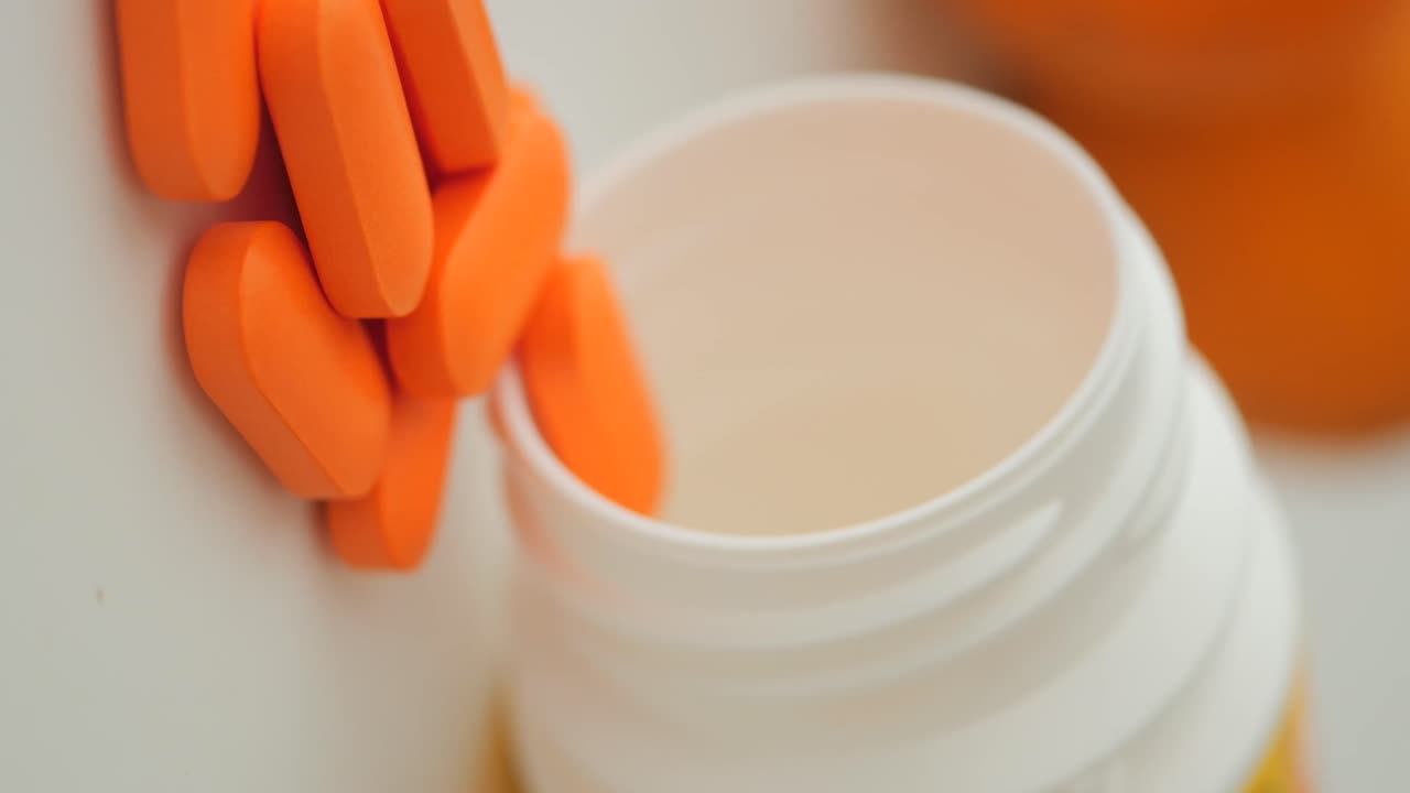 Pillole arancioni che fuoriescono dalla bottiglia