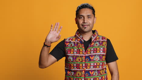 person in traditional clothing doing greeting hand gesture, studio background