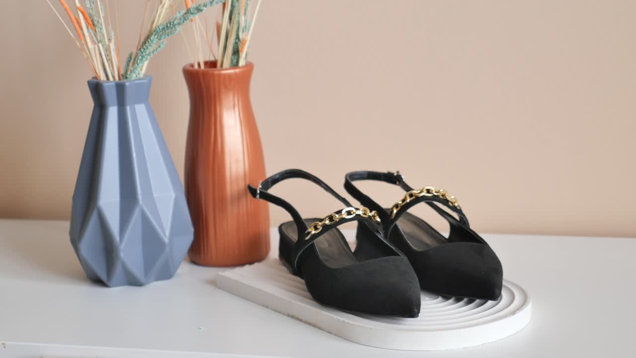 황금 사슬 세부 사항과 함께 우아한 검은 슬링백 신발