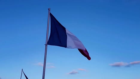 bandiera francese che sventola nel vento sotto il cielo blu