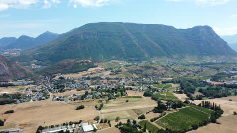 aerial view of a picturesque valley with mountains, village, and vineyards