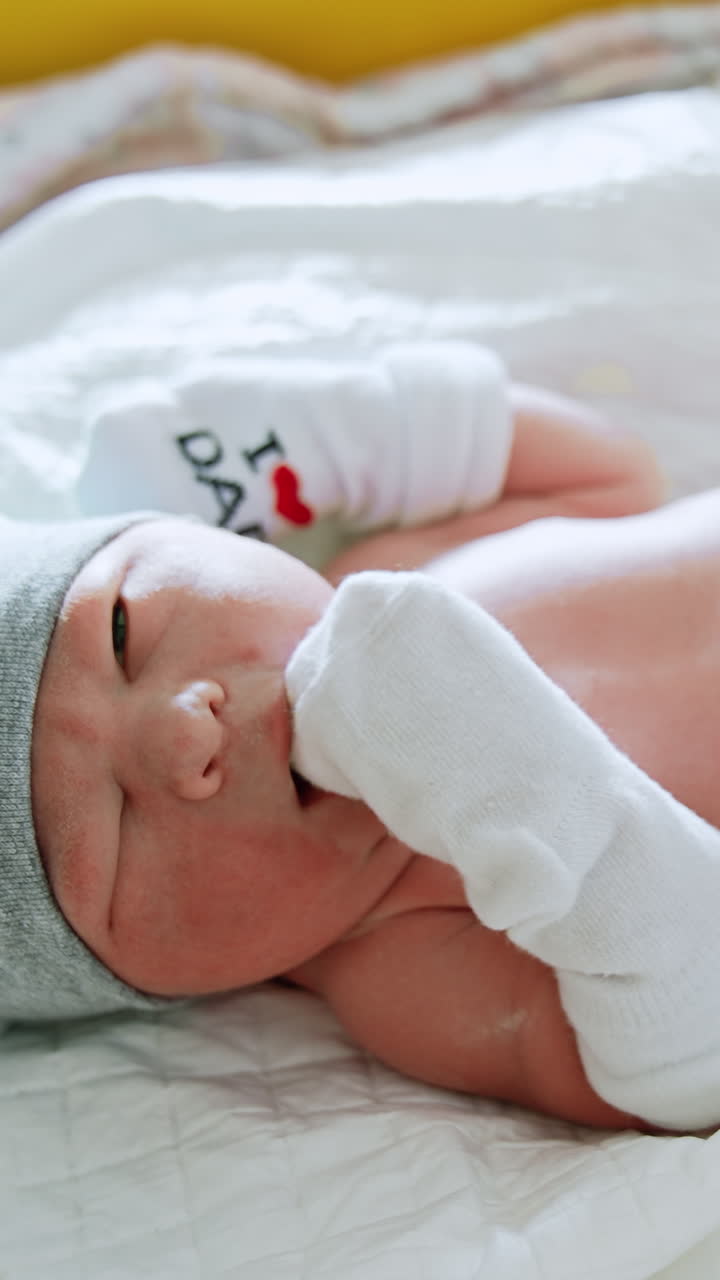 Adorable newborn child in the maternity hospital. Pediatrician listens to the heartbeat of an infant. Nurses take care of a baby. Vertical video