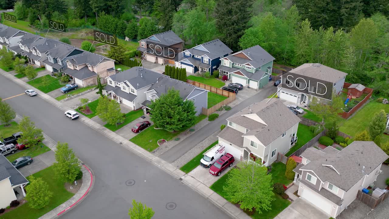 Orbiting aerial view of a suburban neighborhood with &amp;quot;SOLD&amp;quot; signs animating above the houses