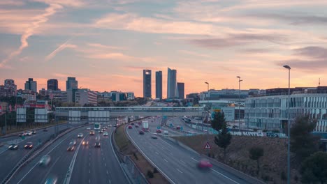 Tag-zu-Nacht-Zeitraffer-Der-Skyline-Von-Madrid-Mit-Der-Autobahn,-Die-Zu-Wolkenkratzern-Führt,-Mit-Wunderschönem-Licht-Und-Wolken