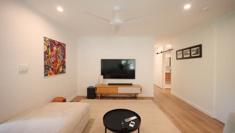 modern lounge room with warm tones, white sofa and louver windows letting in natural light