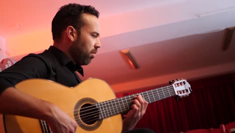 hombre barbudo tocando la canción en la guitarra