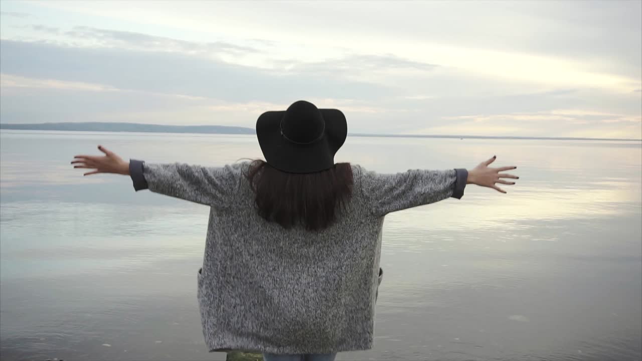 Woman enjoying nature by the lake at sunset