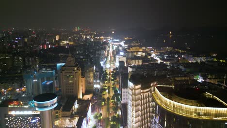 Nighttime-Drone-Journey-Along-Downtown-Hangzhou,-City-Lights-and-High-Rises