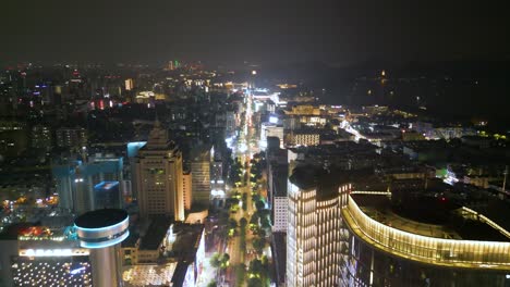 nighttime drone journey along downtown hangzhou, city lights and high rises