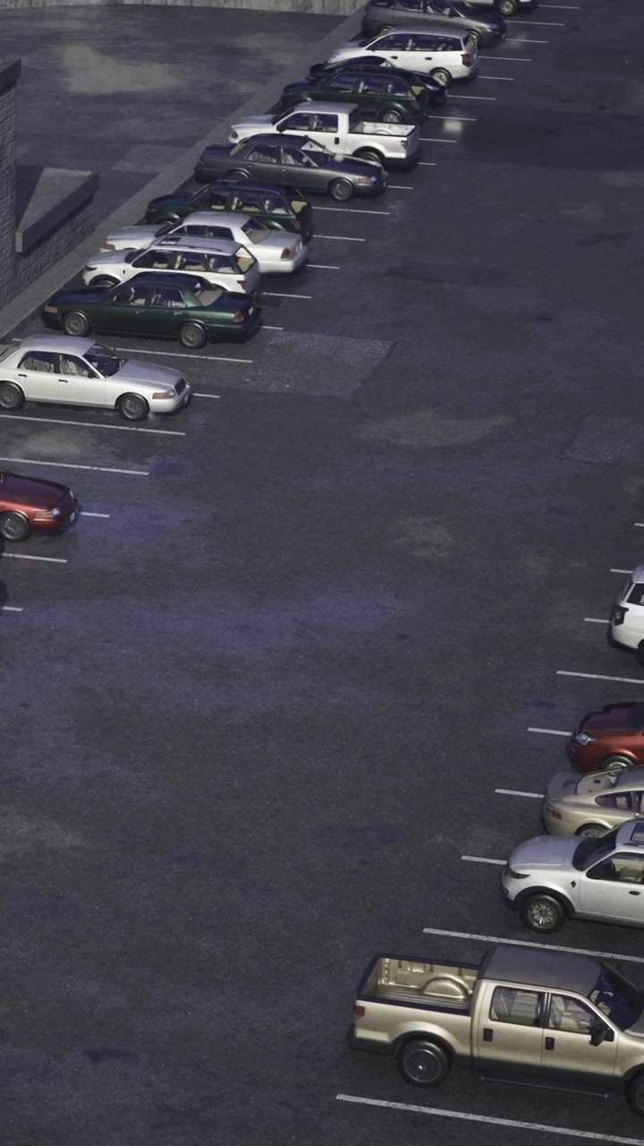 Biler parkeret på en parkeringsplads om natten nær en bygning med begrænset gadebelysning