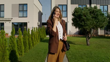 woman talking on phone outside modern homes