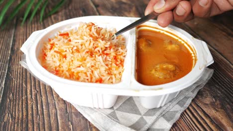 Curry-chicken-and-rice-in-a-take-away-plastic-packet-on-table