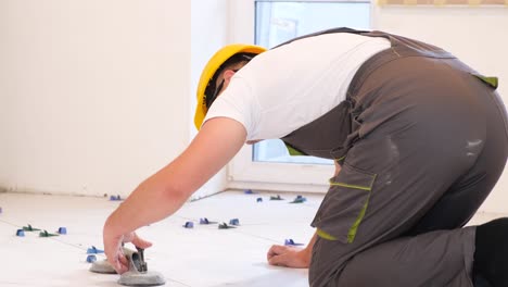 a male construction worker installs a large ceramic tile