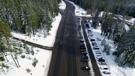 Vista-Aérea-De-Una-Carretera-Que-Conduce-A-Una-Estación-De-Esquí-Con-Estacionamiento-Al-Costado