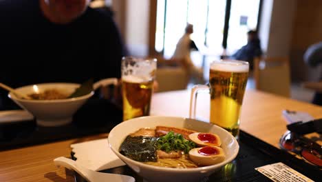 two people enjoying ramen and drinks together