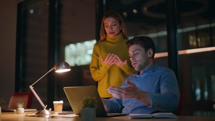 Office team worried failure working together at night workplace closeup