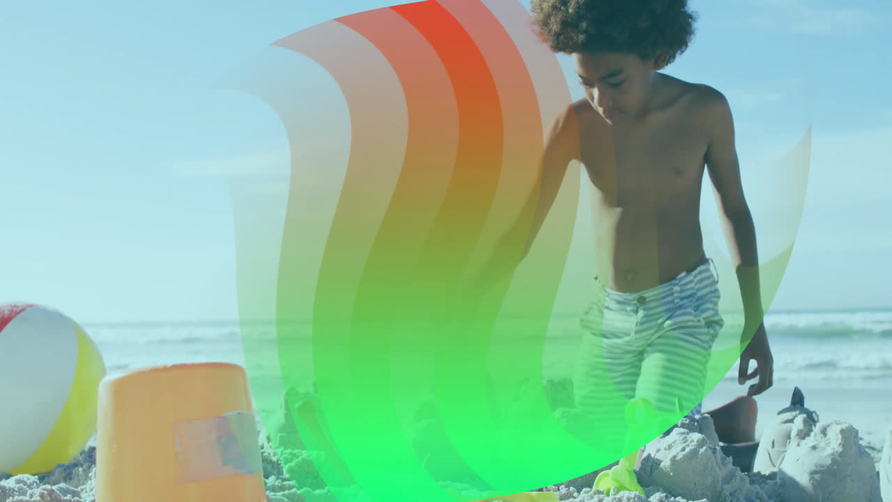 Young boy building sandcastles on beach with colorful wave animation overlay