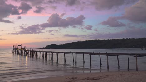 hermosa puesta de sol sobre un muelle en una playa tropical