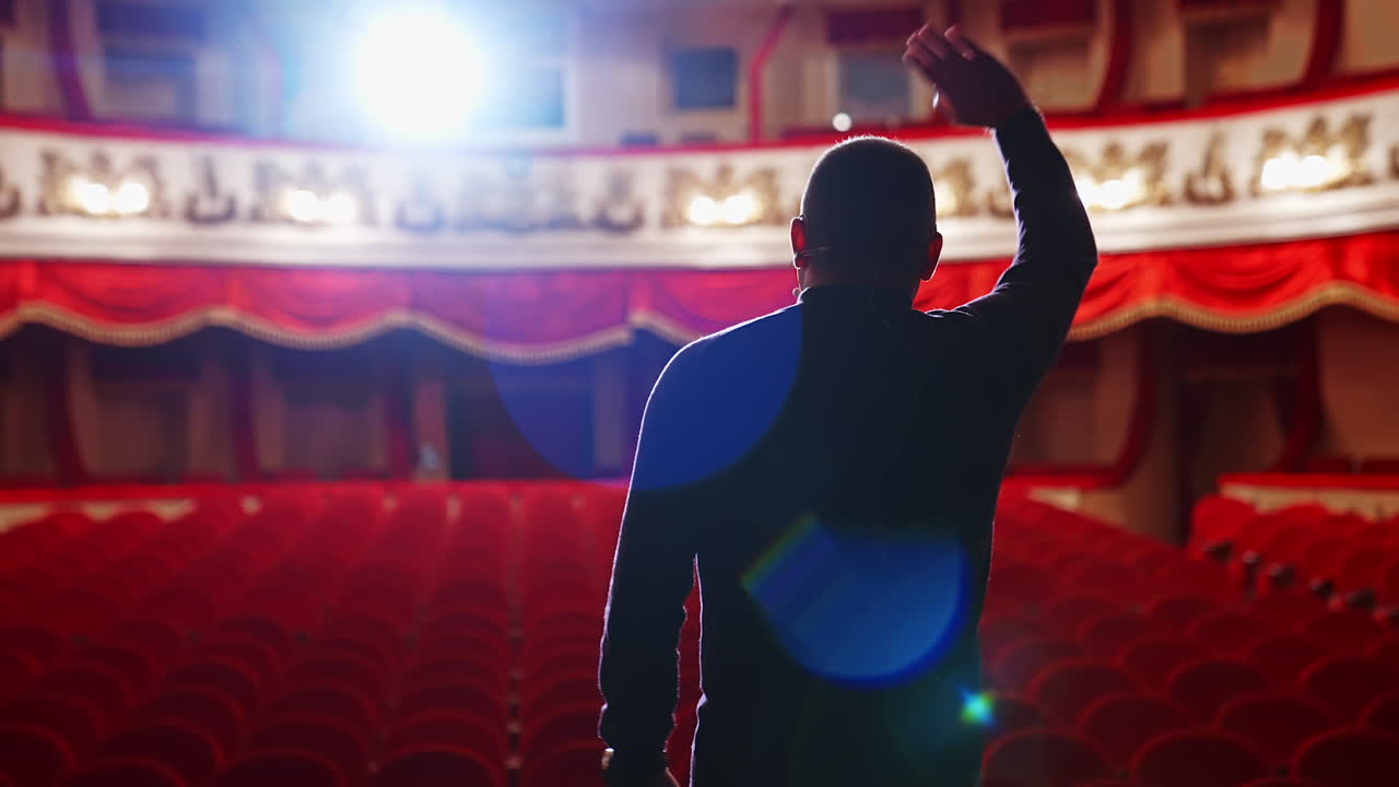 Theater auditorium with no people. Actor on a stage in front of empty hall.