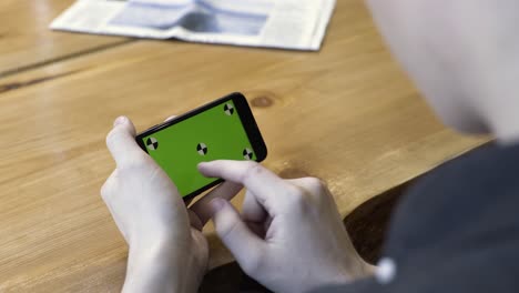 person using a smartphone with a green screen for calibration