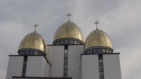 three golden domes of a white church