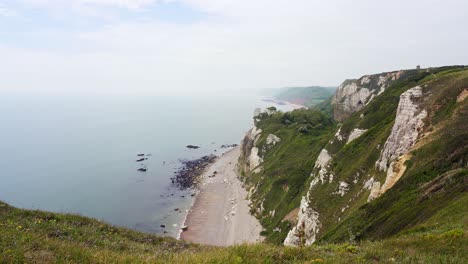 the chalk cliffs and rock formations of branscombe beach in devon on a hazy day