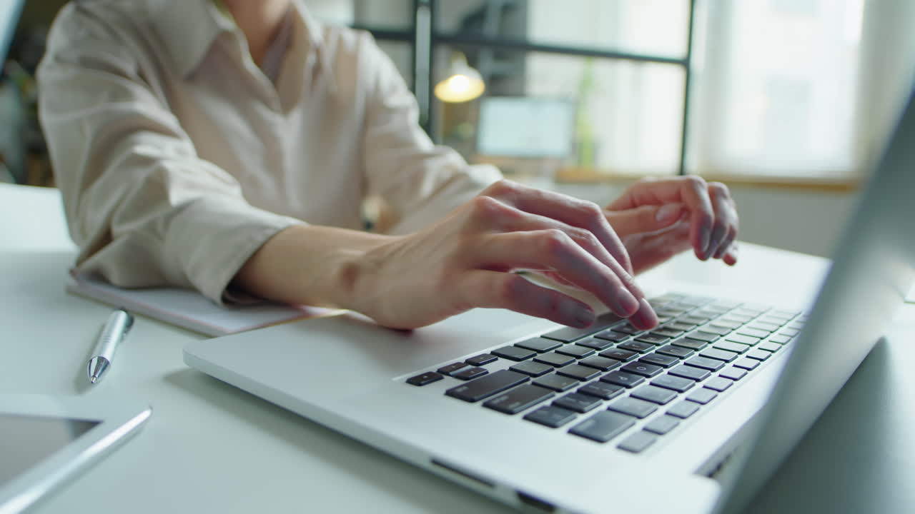 Woman Working on Laptop at Desk in Office
