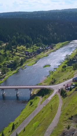 río y puente con vistas a un pueblo en el bosque