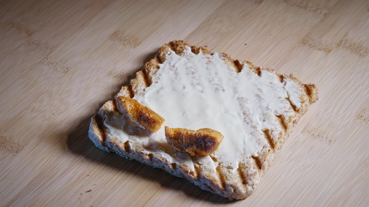 положить обжаренную куриную грудку на ломтик поджаренного цельнозернового хлеба с плавленым сыром