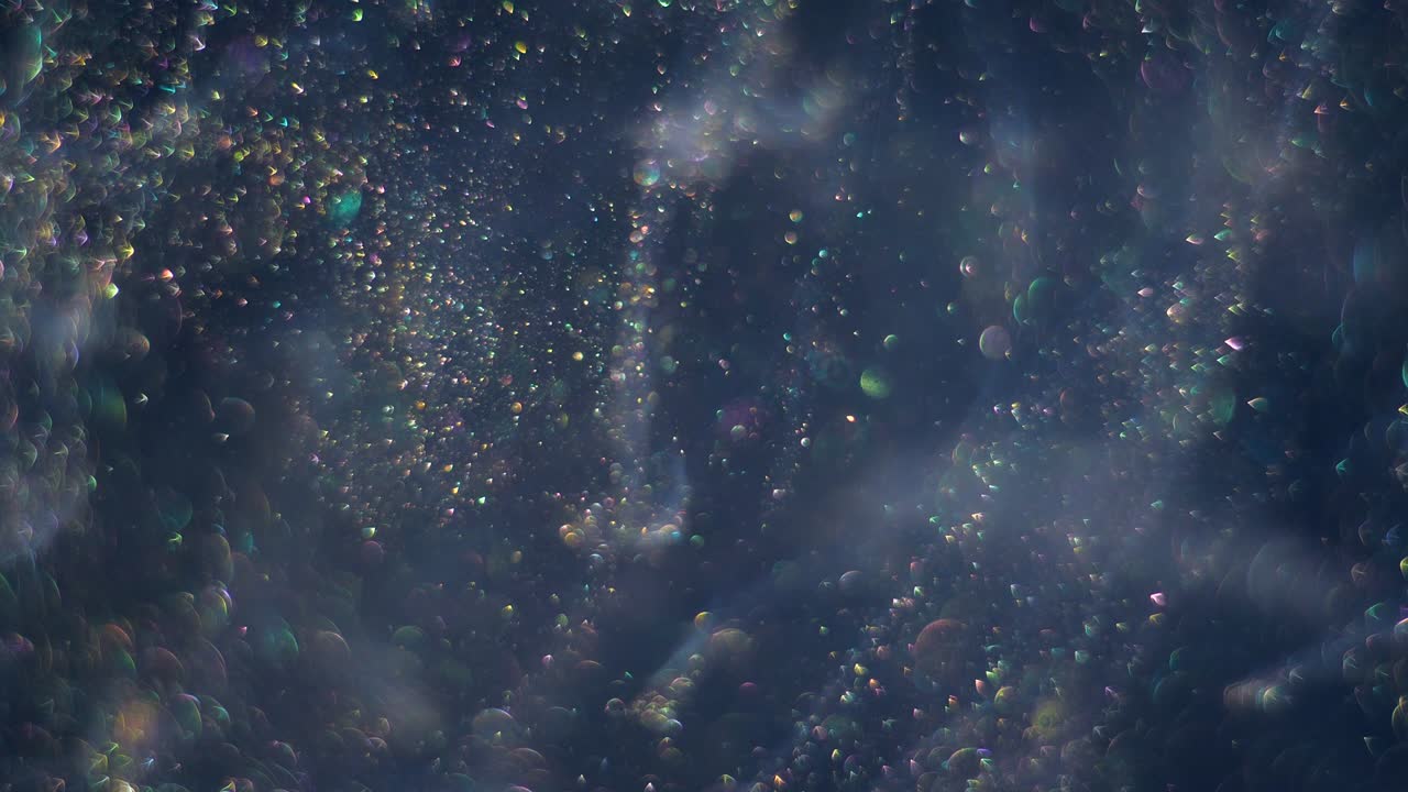 Streams full of tiny bokeh gold glittering bubbles are moving randomly and chaoticlally on the dark space background.