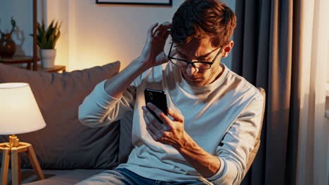 hombre usando teléfono inteligente en casa