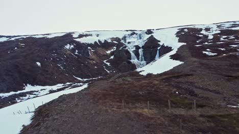 Waterfall-on-snowy-cliff-in-winter