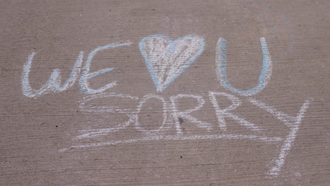 we heart you sorry written in chalk on a sidewalk