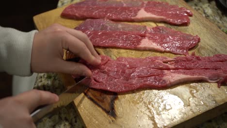 slicing steak on a cutting board in slow motion.
