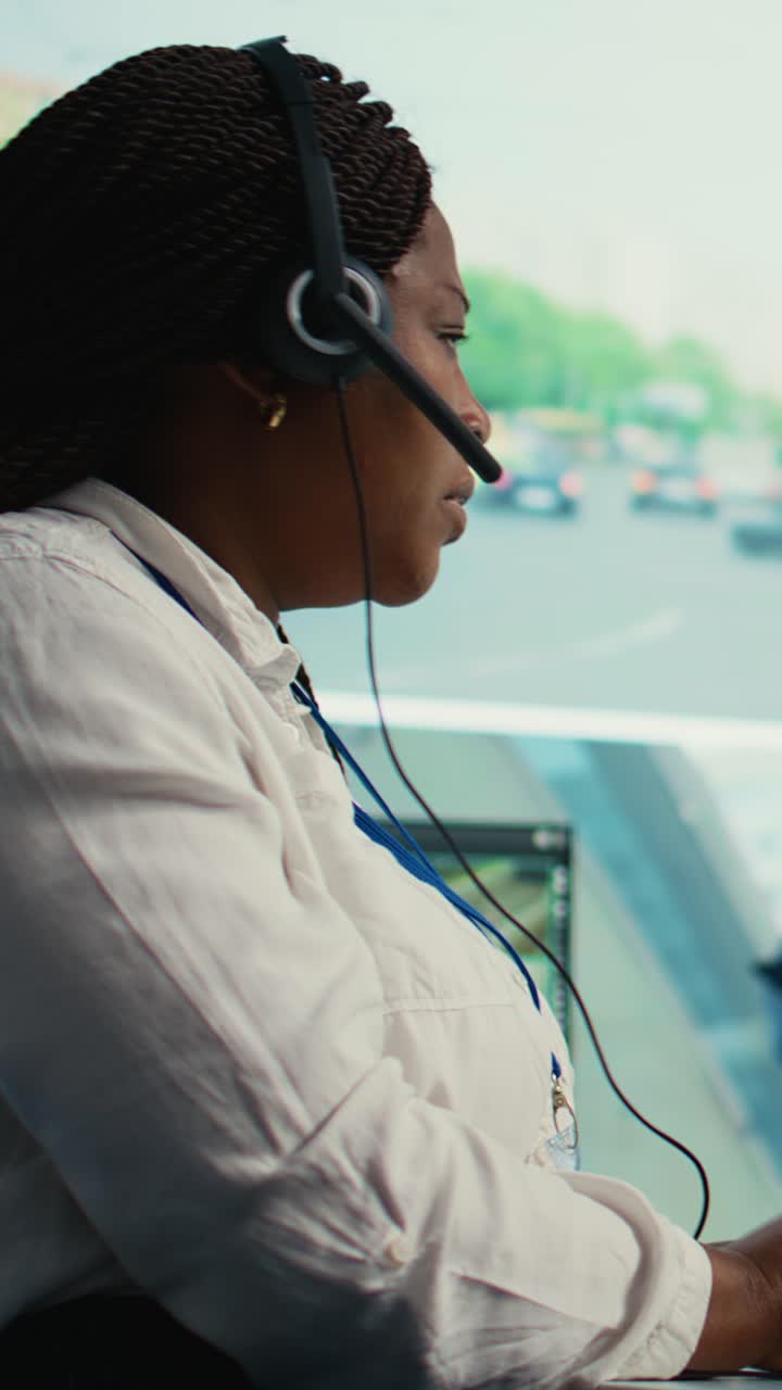 Afroamerikansk kvinne som jobber med headset i kontrollrom
