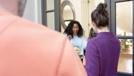 Happy-african-american-couple-receiving-diverse-guests-in-sunny-home