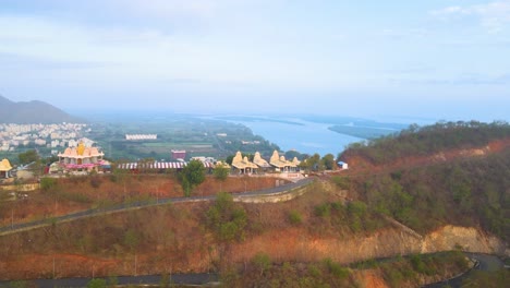 aerial drone shot capturing the essence of vijayawada in the early morning, with the sun rising over a misty skyline.