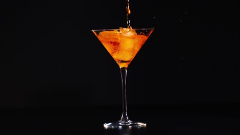 cóctel de naranja en un vaso de martini